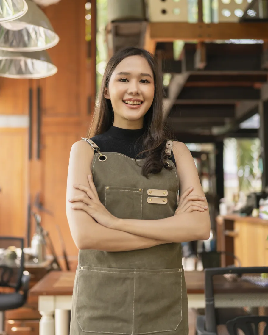 Smiling local cafe owner standing in her shop