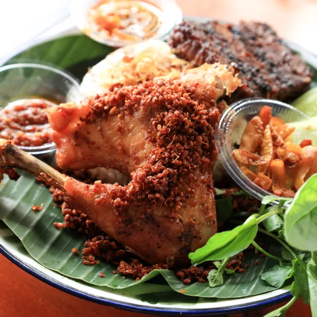Grilled chicken rice platter served on a banana leaf
